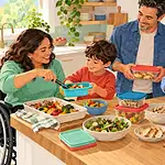 Family packing safe leftovers into colourful reusable containers in a bright kitchen