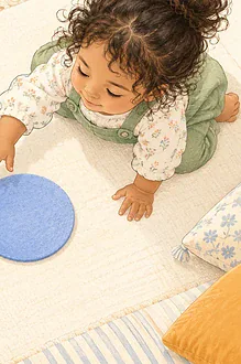 Overhead illustration of a child noticing three large felt circles on a mat.
