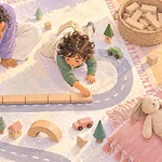 Overhead illustration of a caregiver and child measuring a toy road with matching blocks.