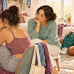 A caregiver and teenager reviewing a social media feed together with a supportive expression